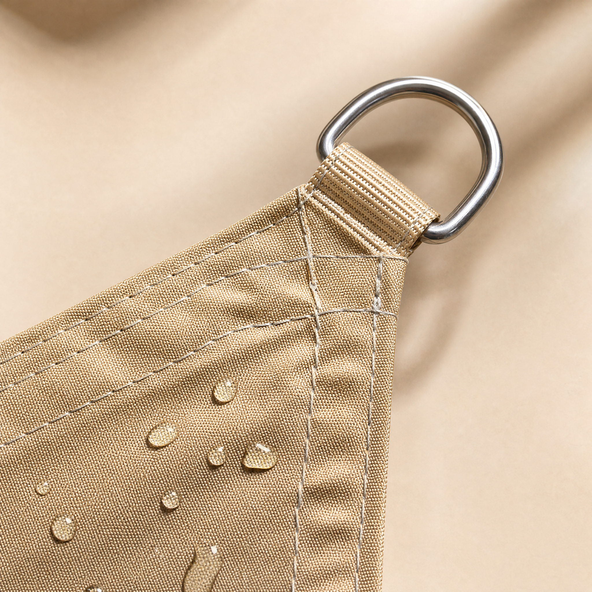 Reinforced shade sail corner with layered fabric, double stitching and metal hardware